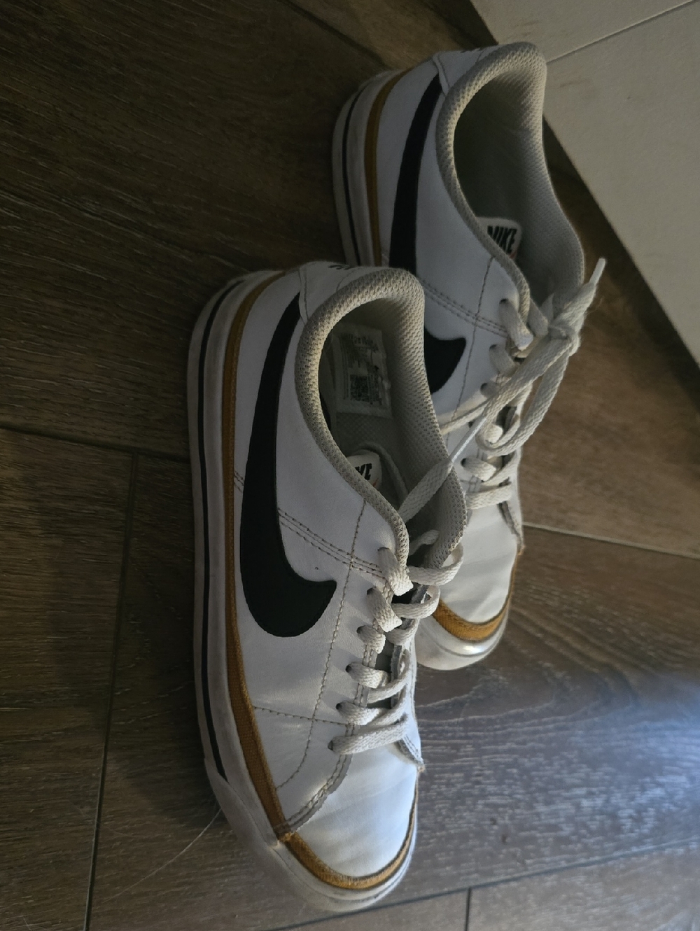 Nike White Sneakers with Black Swoosh and Gold Accent